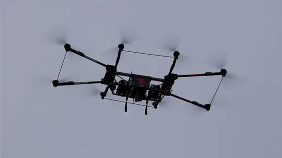 Eine schwarze Drohne fliegt in der Luft.