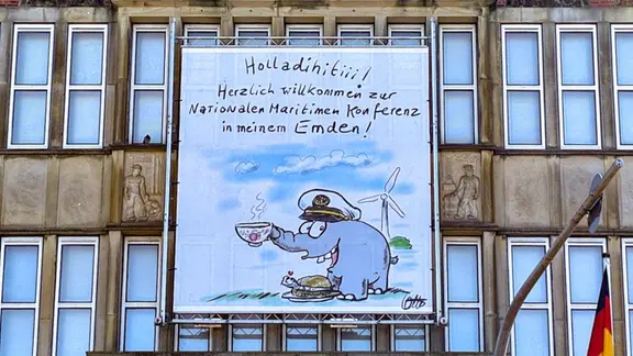 Ein Plakat mit einem Ottifanten hängt an einer Hausfassade