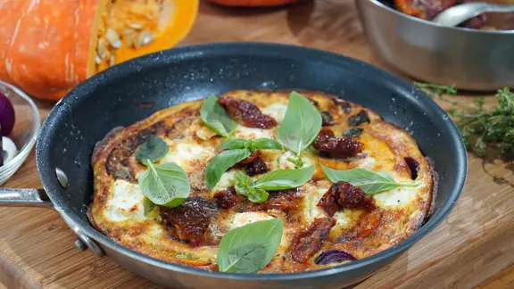 Eine Pfanne mit Kürbis-Frittata, Feta und getrockneten Tomaten