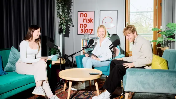 Drei junge Erwachsene sitzen in einem modern eingerichteten Podcast-Studio