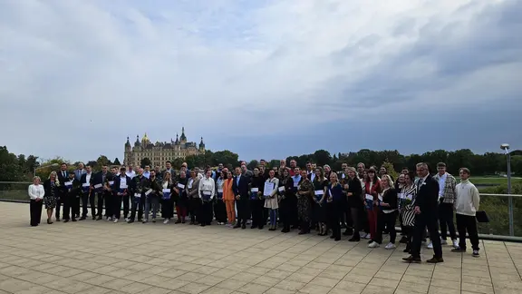 viele Menschen stehen im Halbkreis