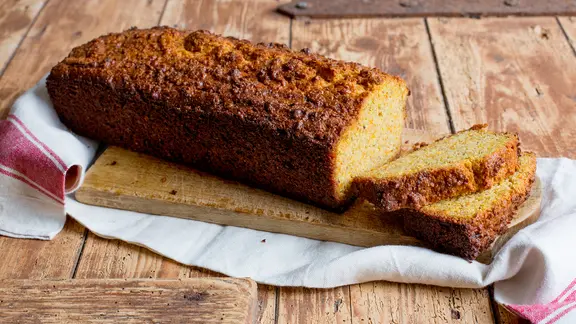 Ein angeschnittener Kürbiskuchen liegt auf einem Brett.