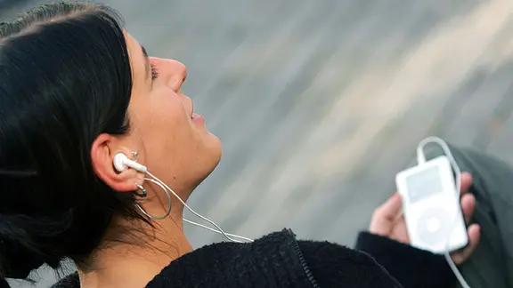 junge Frau hört mit einem iPod Musik