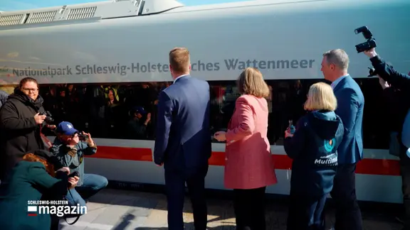 Mehrere Menschen taufen einen ICE L in Westerland