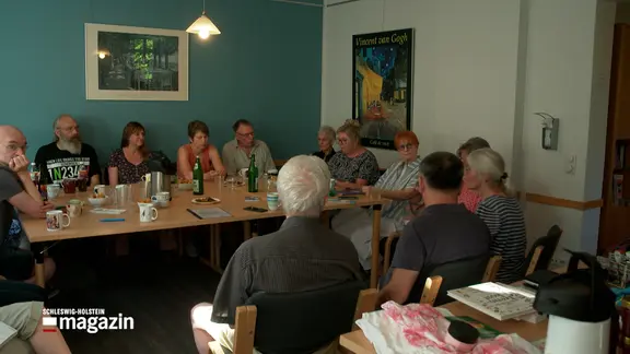 Menschen sitzen an einem Tisch