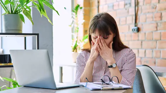 Eine Frau sitzt verzweifelt vor einem Computer.