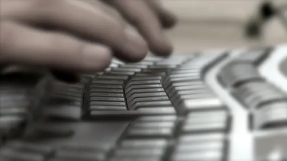 Eine Hand tippt auf einer Computer-Tastatur