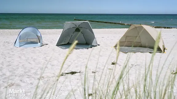 Am Strand sind drei Strandmuscheln verschiedener Anbieter aufgebaut.