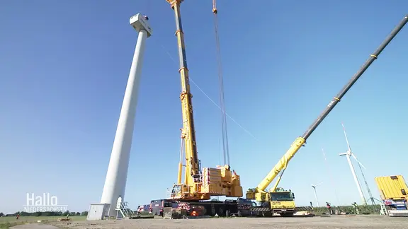 Ein Kranwagen vor einer Windkraftanlage in Krummendeich.
