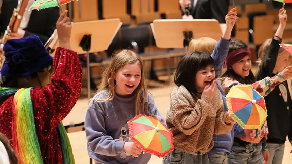 Konzertszene: Kinder mit bunten Schirmchen