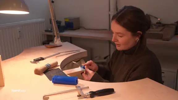 Goldschmiedemeisterin Neele Kaffitz schleift an einem Schmuckstück in ihrer Werkstatt. 