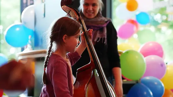 Mädchen beim NDR Kindermusikfest probiert den Kontrabass aus