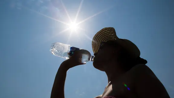 Eine Frau trinkt aus einer Flasche Wasser.