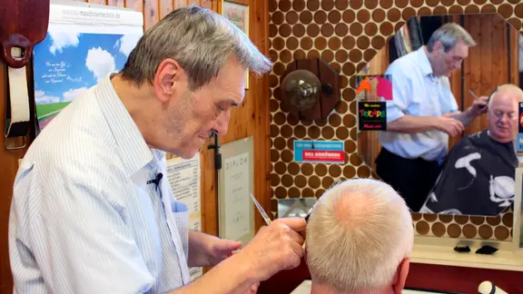 Jürgen Hesse in seinem Frisörsalon bei der Arbeit.