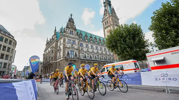 Amateur-Teilnehmer bei den Cyclassics in Hamburg fahren am Rathaus vorbei.
