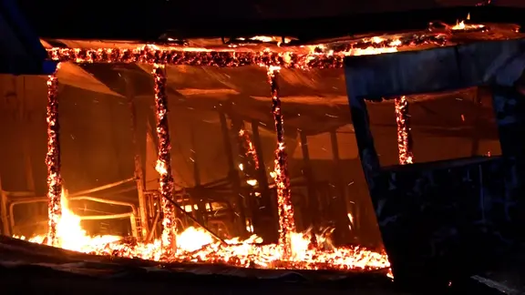 Ein Schweinestall steht in Flammen.