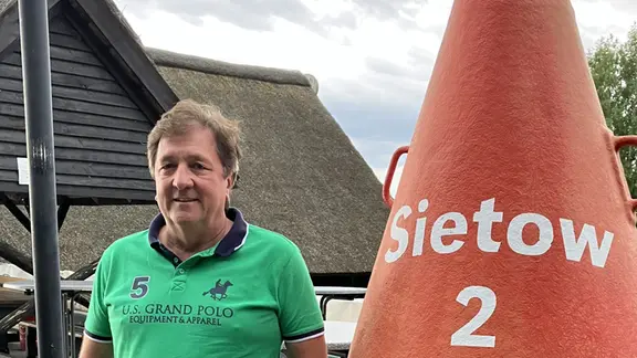 Bürgermeister Bermudez neben einer Boje mit der Aufschrift Sietow