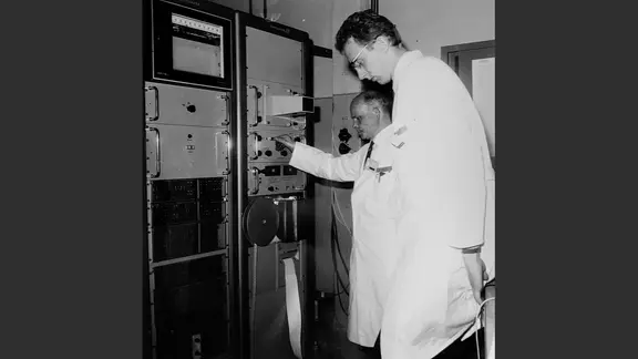 Kernphysiker Hans-Georg Priesmeyer und ein Kollege bei der Arbeit an einer Anlage, undatierte Schwarz-Weiß-Aufnahme.