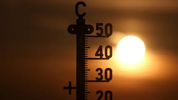 Ein Thermometer vor einem Sonnenuntergang