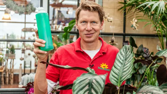 Gärtner Peter Rasch hält eine Plastikflasche hoch