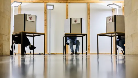 Wähler geben in Wahlkabinen ihre Stimmen für die Kommunalwahl ab. 
