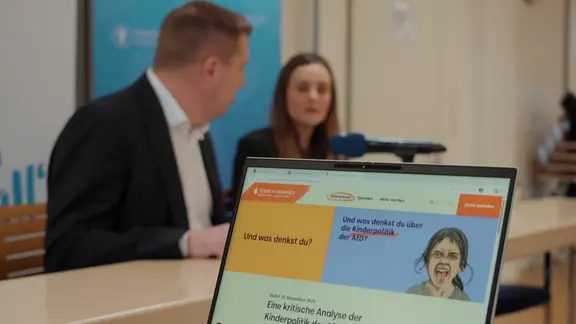 Zwei Personen bei einer Pressekonferenz