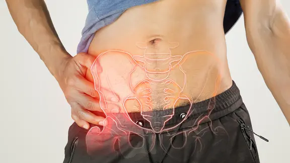 Mann hält sich Hüfte, darüber liegt 3D-Grafik des Hüftknochens (Bild: colourbox.de/Tharakorn arunothai)