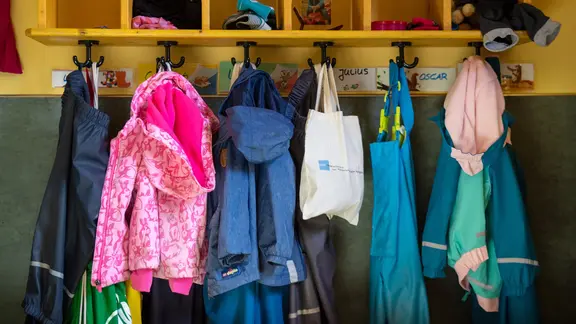 Kinderjacken hängen im Kinderkarten an der Garderobe
