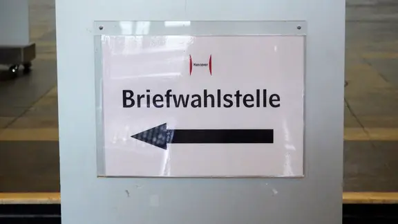 Ein Schild weist den Weg zu einer Briefwahlstelle.