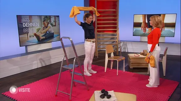 Zwei Menschen dehnen sich im Studio.