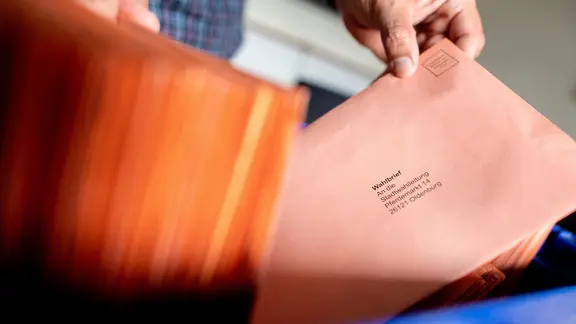 Ein Mitarbeiter aus dem Wahlbüro sortiert die per Briefwahl eingegangenen Stimmzettel zur Kommunalwahl.