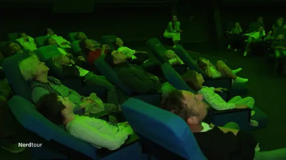 Menschen starren in die Luft während eines Besuchs im Planetarium.