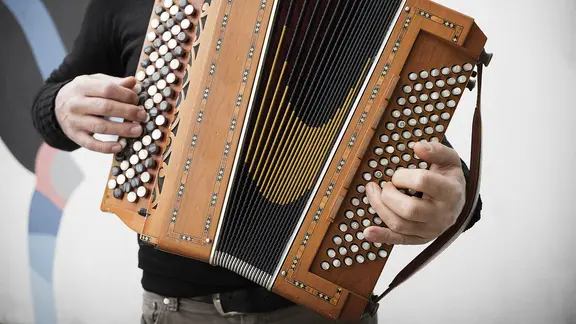 Ein Musiker bedient ein Akkordeon.