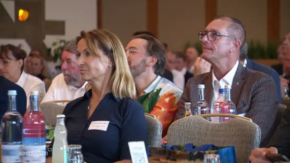 Bei einem Ernährungsgipfle sitzen viele Zuhörende in Sitzreihen in einem Saal.