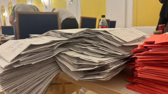 Ausgezählte Wahlzettel auf einem Tisch.