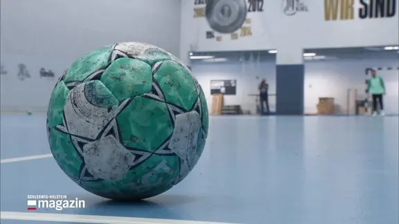 Ein Handball in einer Sporthalle.