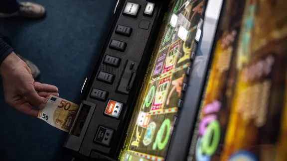 Ein Geldschein wird in einen Fun-Game-Automat geschoben.