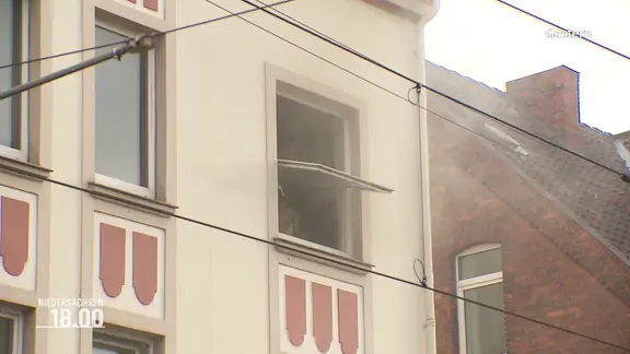 Ein offenes Fenster aus dem Rauch kommt.