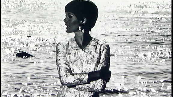 Eine Frau im schillernden Kleid vor dem Meer - Fotografie von F.C. Gundlach