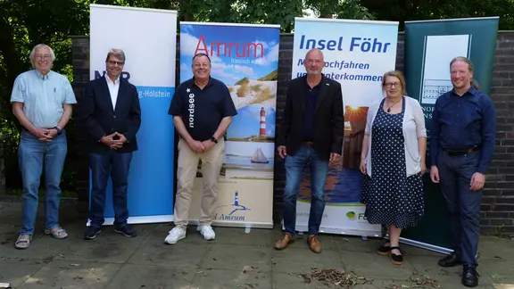 Vertreter des friesischen Schreibwettberbs stehen vor Aufstellern.