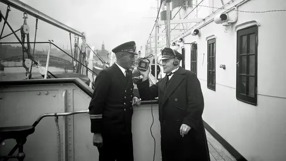 Kurt Esmarch (r.), Sprecher des "Hafenkonzerts", bei einem Interview auf der "Cap Arcona" 1931.
