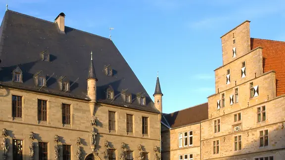 Das Rathaus in Osnabrück wird von der Sonne angestrahlt.