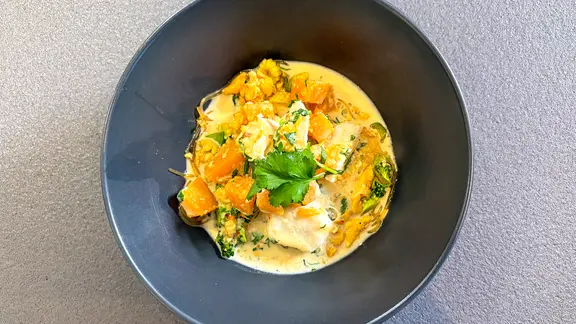 Fischcurry mit Glasnudeln in einem tiefen Teller angerichtet