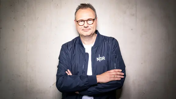 Hendrik Lünenborg lehnt an einer Wand