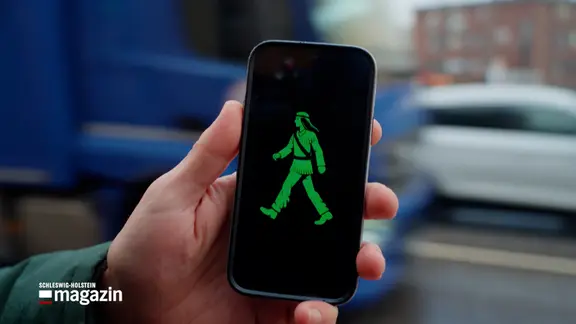 Auf einem Smartphone ist ein Piktogramm eines grünen Ampelmännchen im Winnetou-Design zu sehen