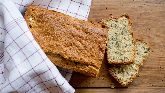 Ein aufgeschnittenes Eiweißbrot liegt auf einem Brett.