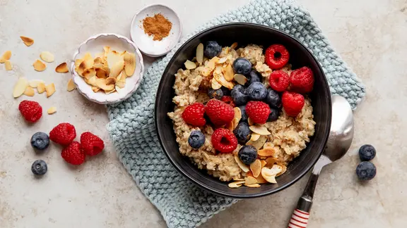 Eine Schale mit einem Porridge mit Himbeeren und Heidelbeeren.