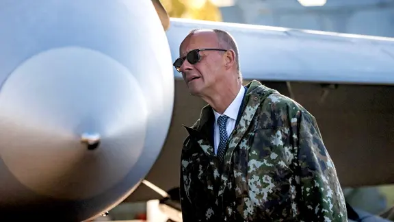 Bundeskanzler Merz betrachtet auf dem Luftwaffenstützpunkt Lapland Air Wing einen F/A18 Hornet Jet vor Beginn des Arktis Gipfels in Finnland.