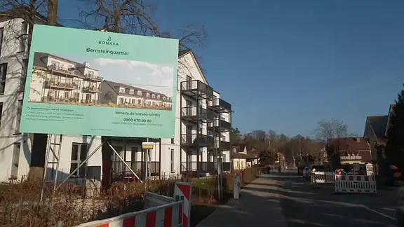 Straßenzug mit Bauschild an der Seite