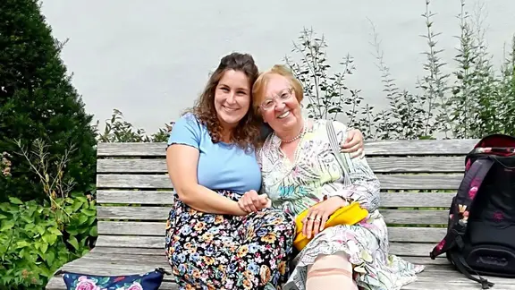 Die Freundinnen Julia und Christa sitzen auf einer Bank
